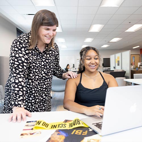 ksu faculty helping a student with their work.