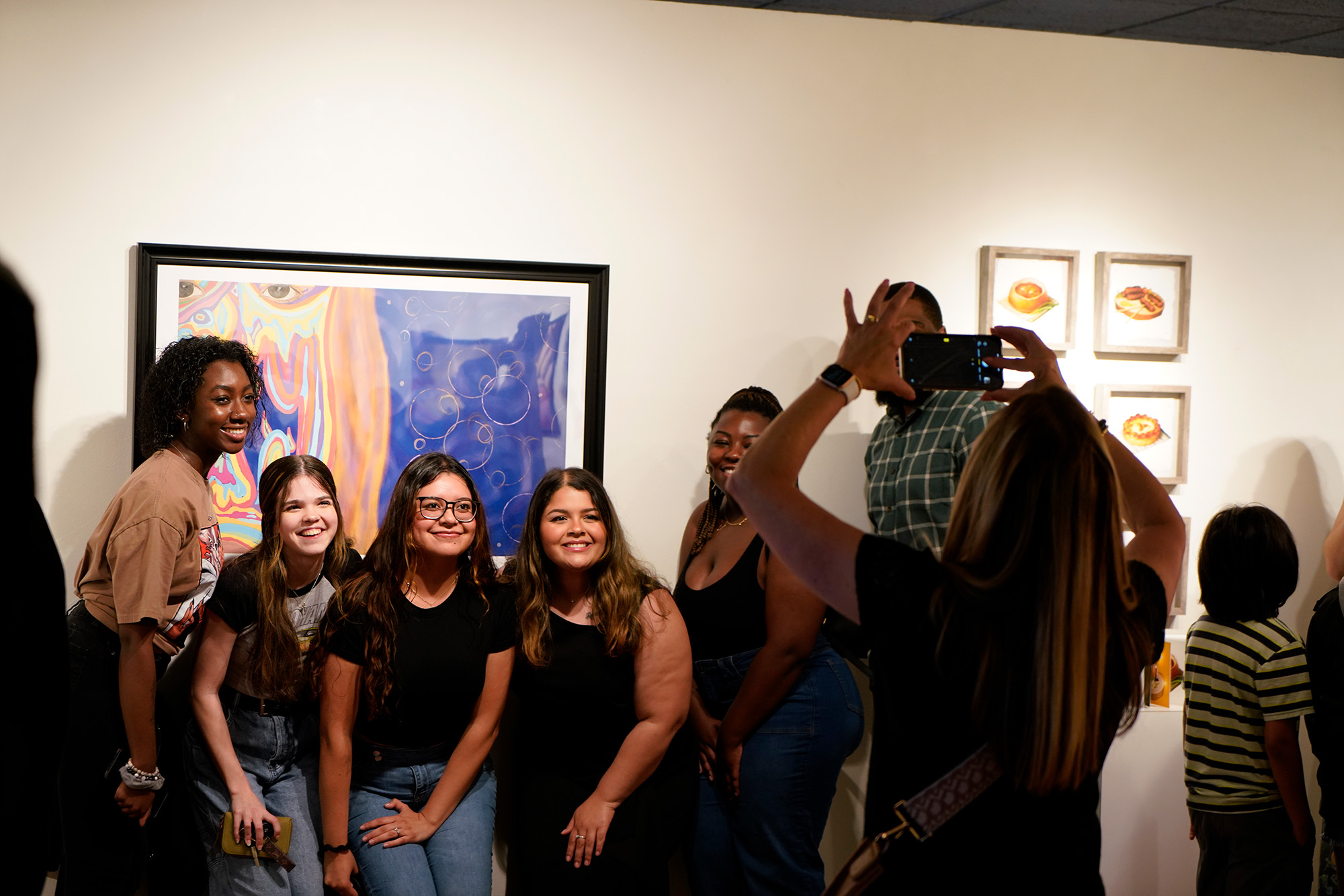 Students in front of their artwork posing for a group photo