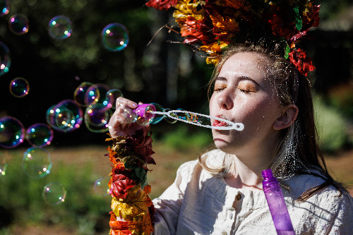 image of girl on costume blowing bubbles