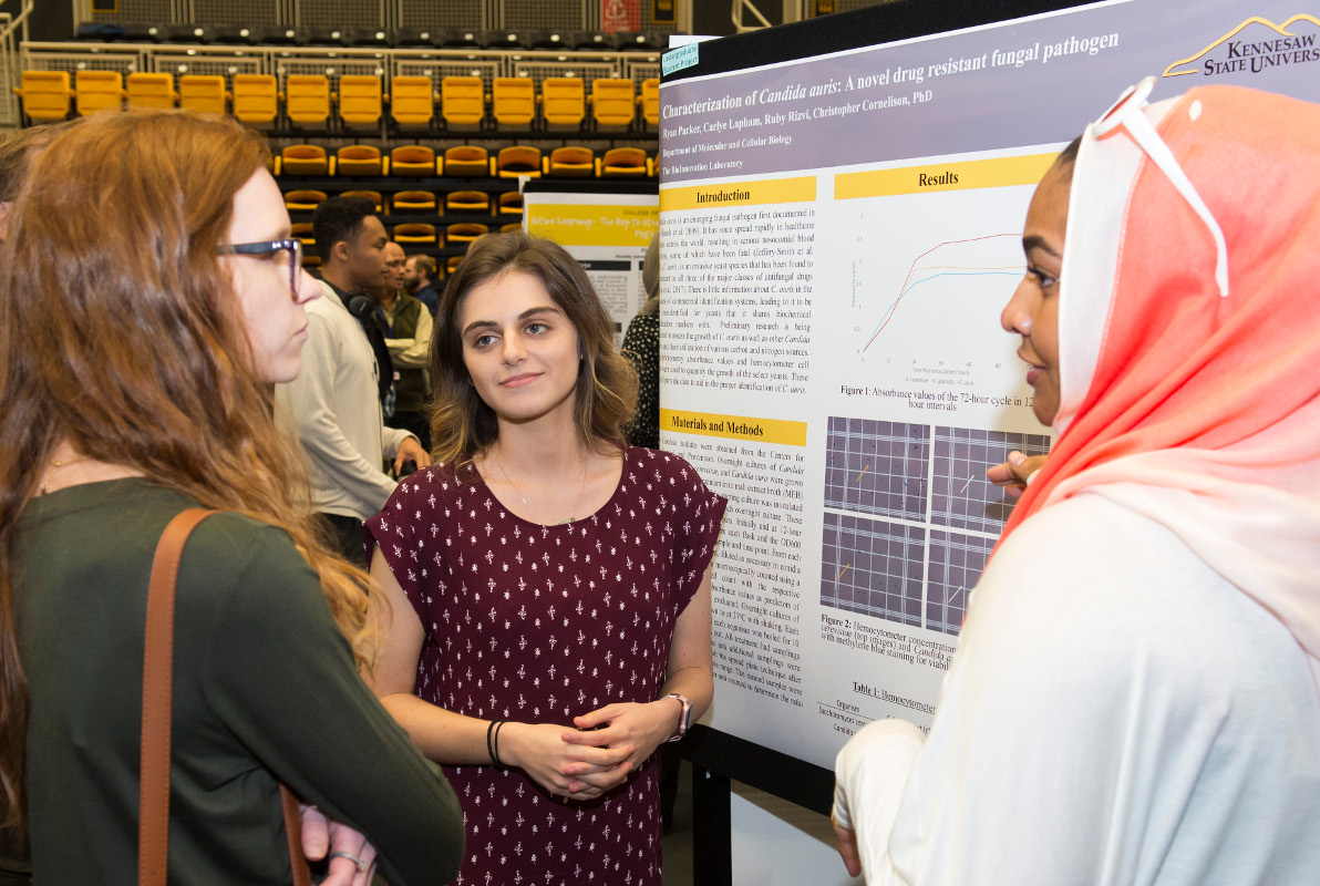 students standing around presentation poster