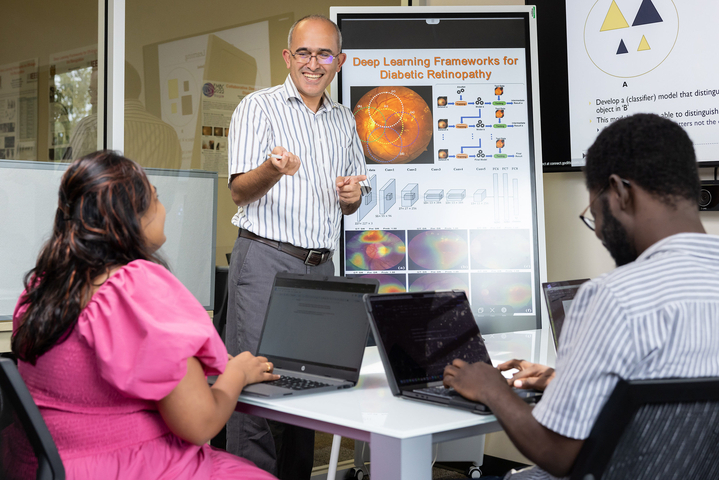 Professor Ramazan Aygun speaks with students in his lab.