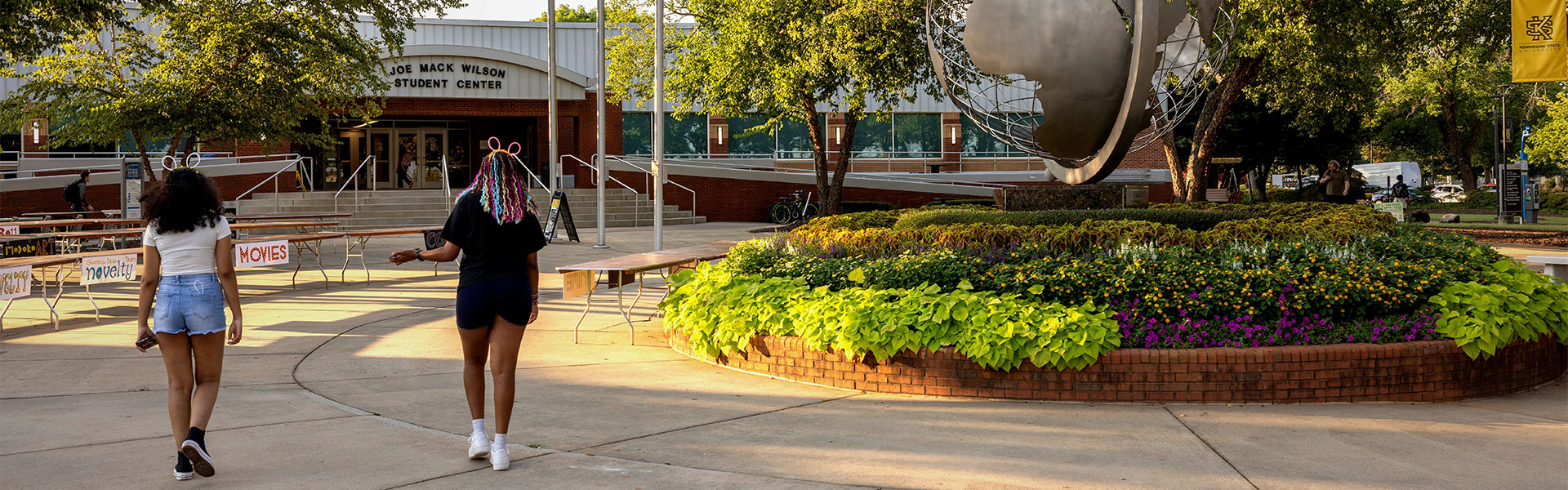 students walking to the joe mack wilson student center with globe in right forefront.