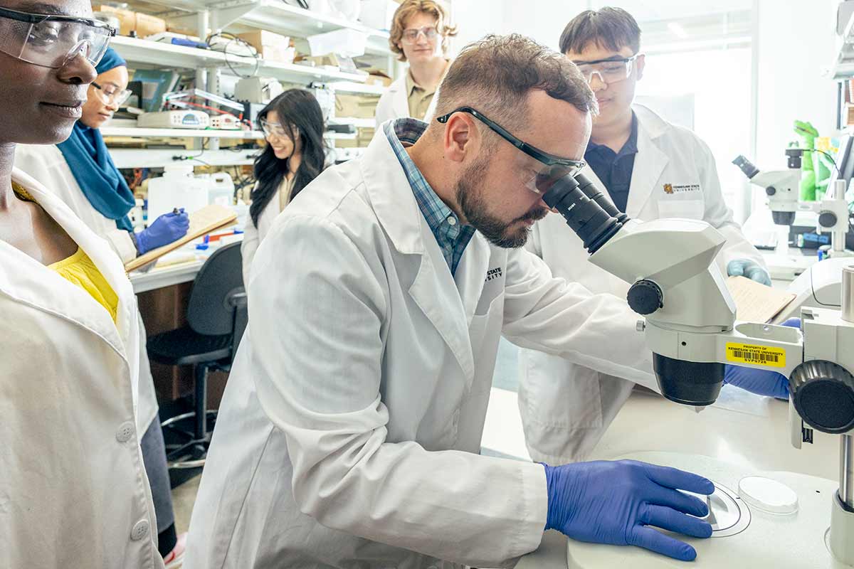 Photo of Dr. Brandon Carpenter working with students in a laboratory. / Photo of Dr. Brandon Carpenter working with students in a laboratory.