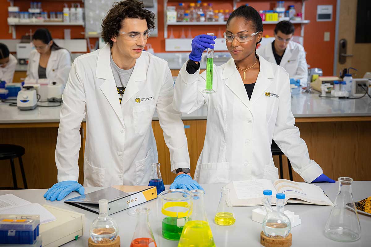 Students in a chemistry class measuring chemicals. / Students in a chemistry class measuring chemicals.