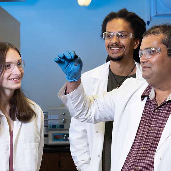 Physics faculty and students in a research laboratory