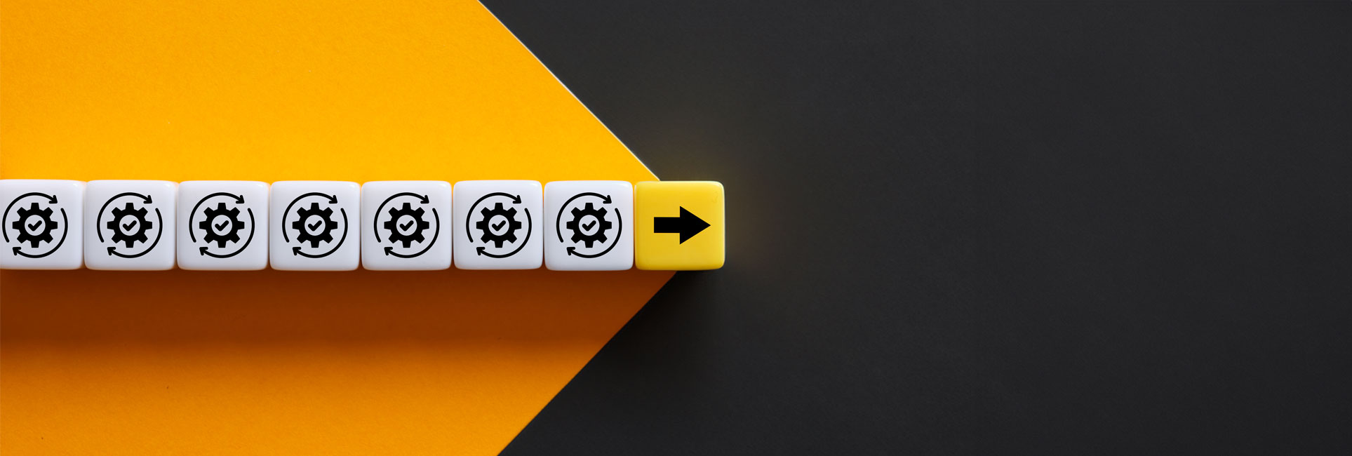 A row of white dice with a gear symbol on each face, followed by a yellow die with a right-pointing arrow. The dice are arranged on a surface with ksu gold and black background.