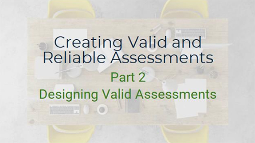 A top-down view of a conference table with a laptop, keyboard, mouse, pens, and papers scattered across it. The text "Creating Valid and Reliable Assessments" and "Part 2 - Designing Valid Assessments" is written on the table. Two yellow chairs are visible on either side of the table.