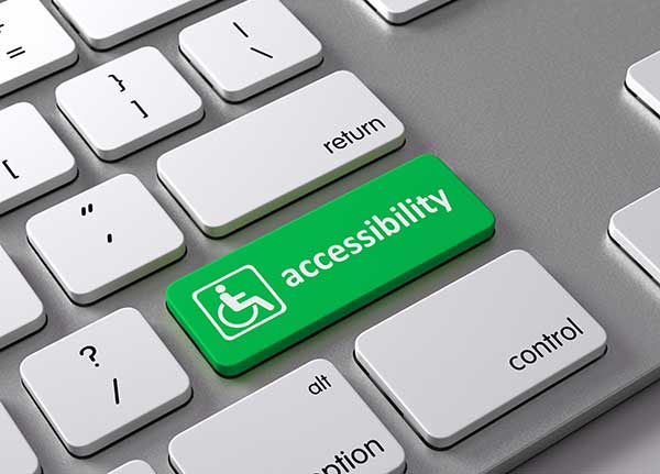 A computer keyboard with a green key that reads accessibility