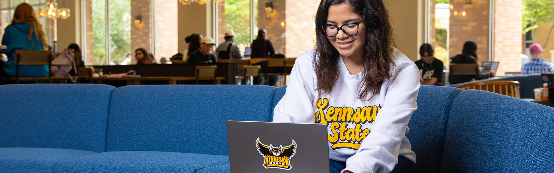 ksu student in a lounging area using their laptop.