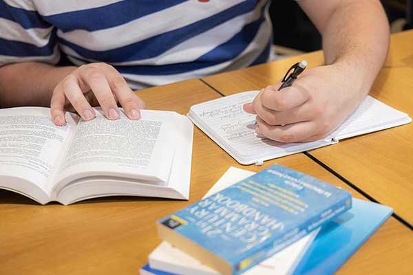 student taking notes from text book