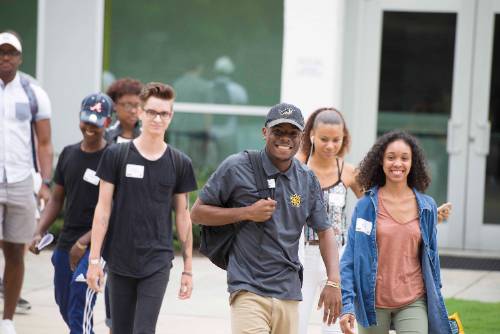 group of ksu students walking on campus with a tour guide.