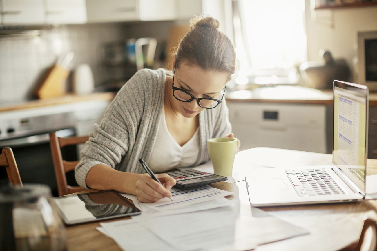 Woman at table working on a laptop and tablet