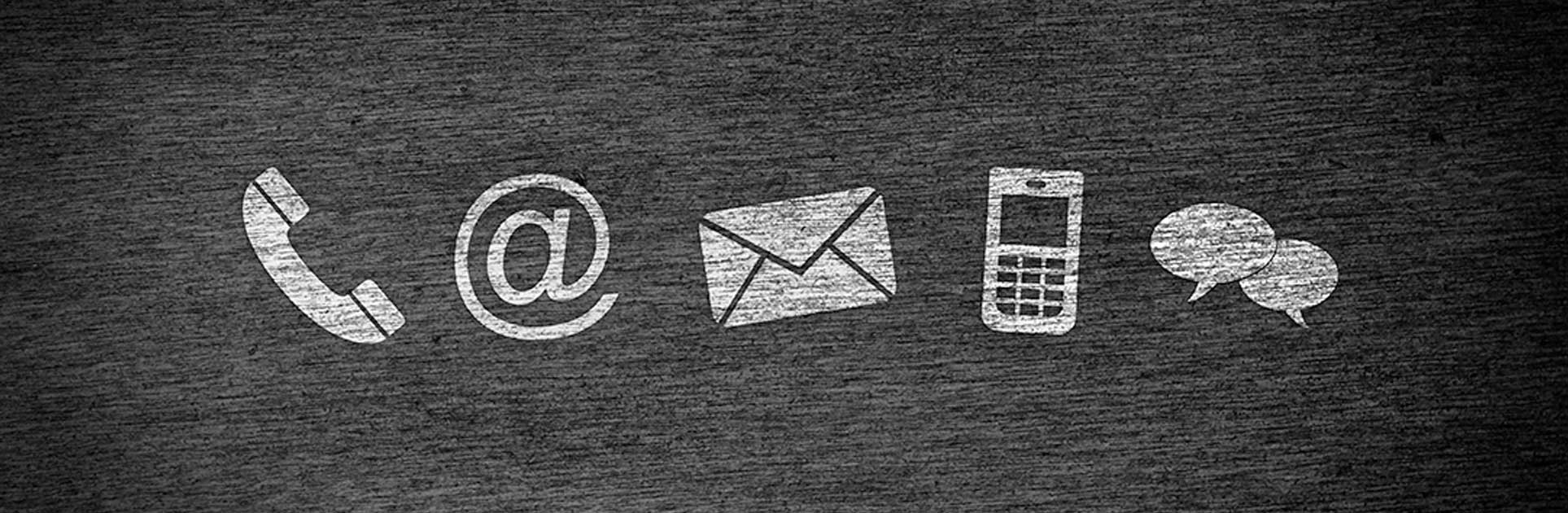 Icons representing common contact methods: phone, email, and message on a black chalk board.