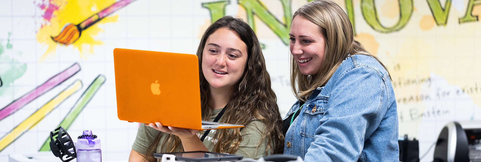 two female teachers examine a computer screen in the Instructional Technology lab on the Kennesaw State campus.