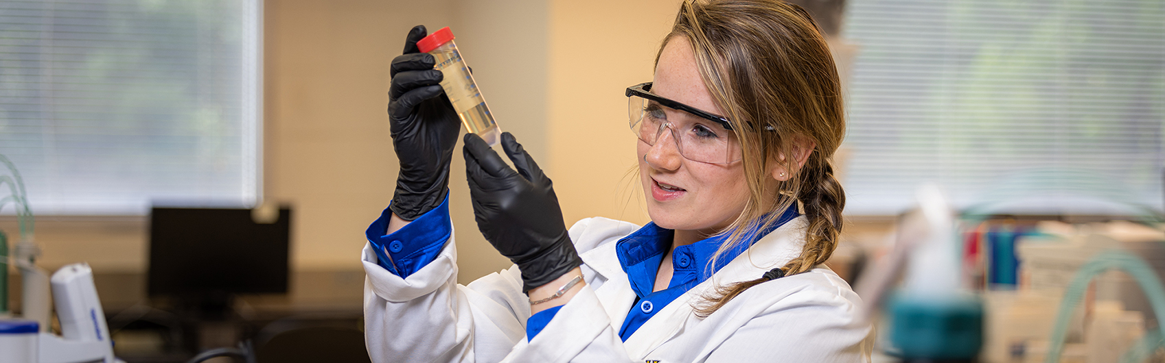 Student in laboratory with a test tube.