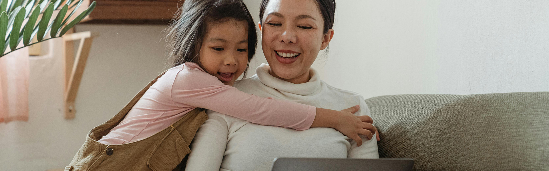 A woman and child looking at laptop computer.