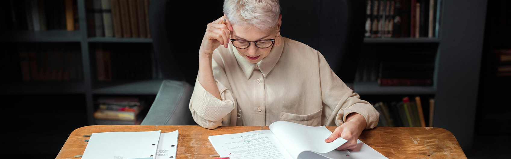 professional writer reading papers on wooden desk