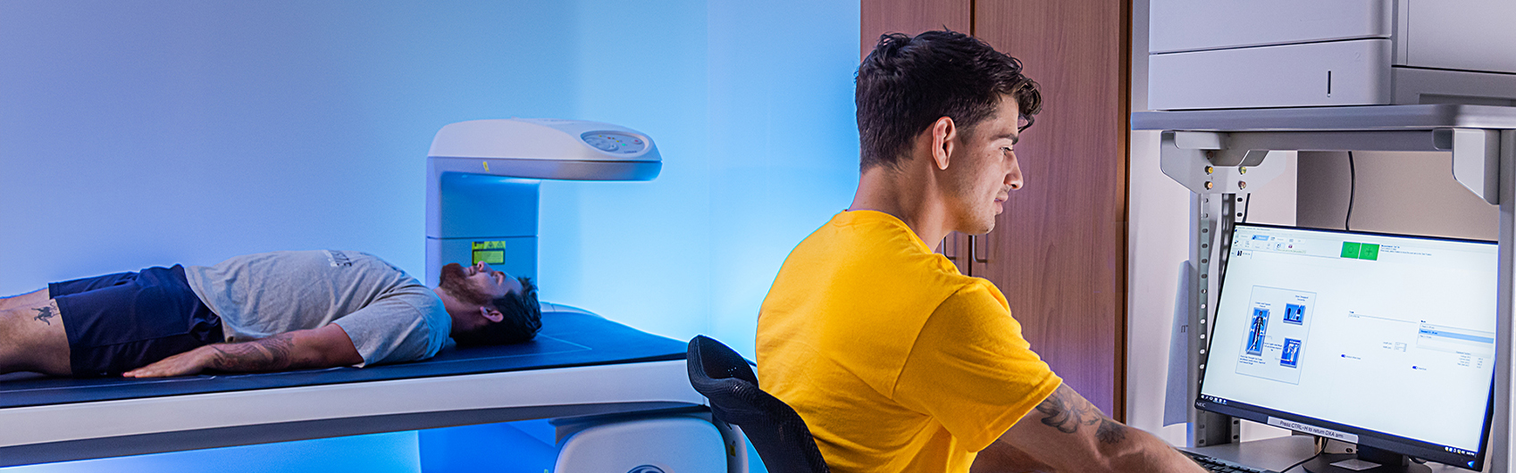 exercise science student using xray machine on another student