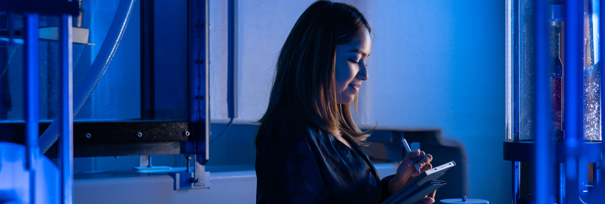 Kennesaw State Graduate student working in a lab and using a tablet to calculate data for research.