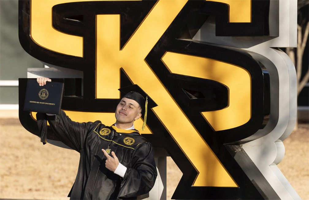 Graduate student proudly holding diploma