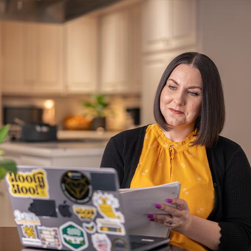student using their laptop at home for online class.