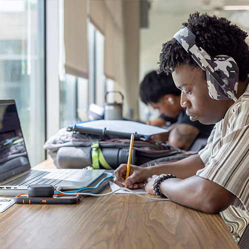 students on campus sitting at a table studying.