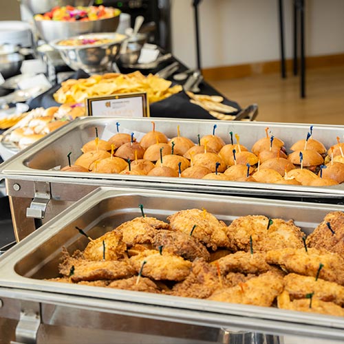 Trays full of food sitting on a table.