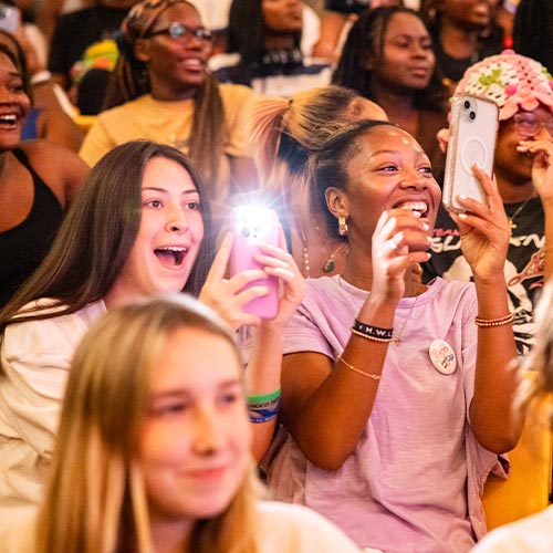 Large group of students excited and taking pictures of the event.