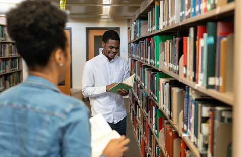 ksu student at the library holding a book.