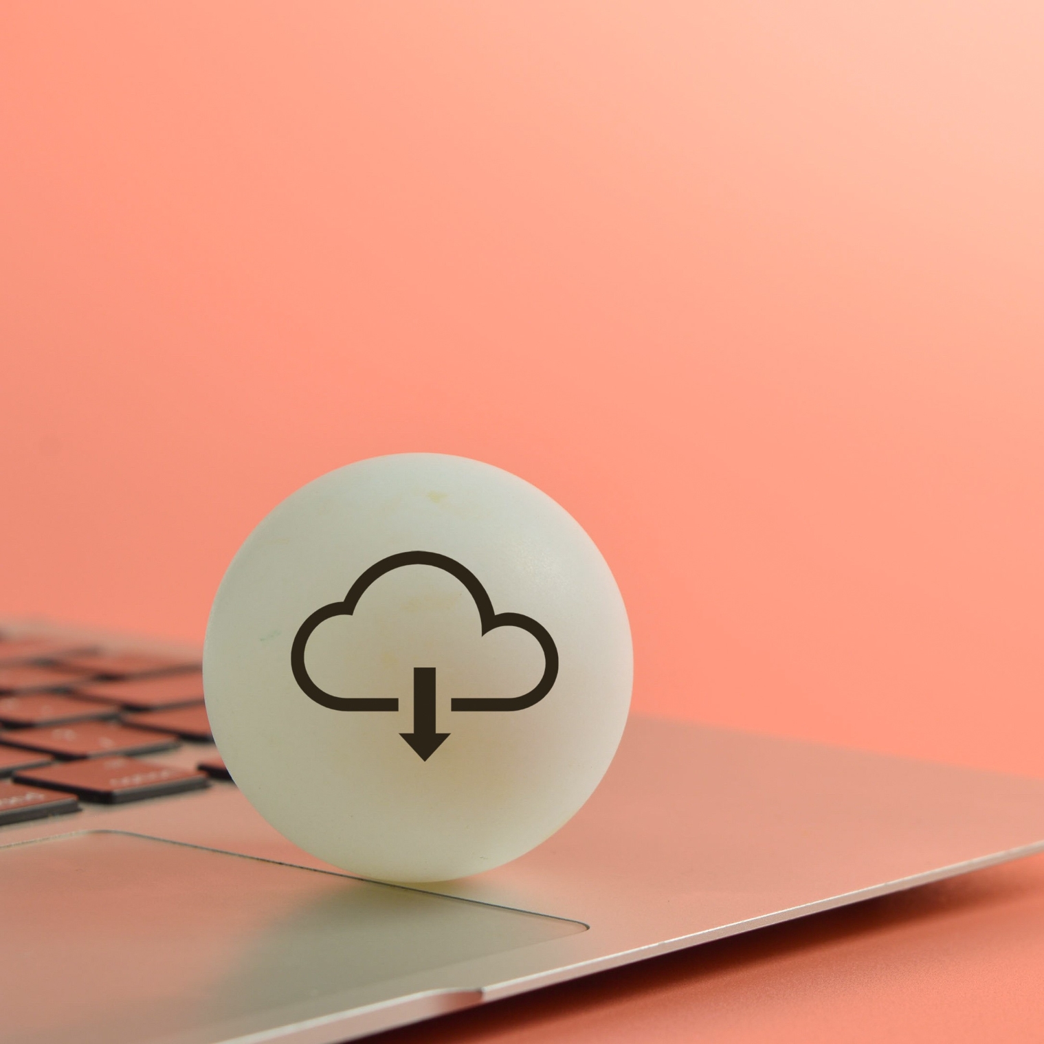 A white button with a cloud download icon hovering over a laptop.