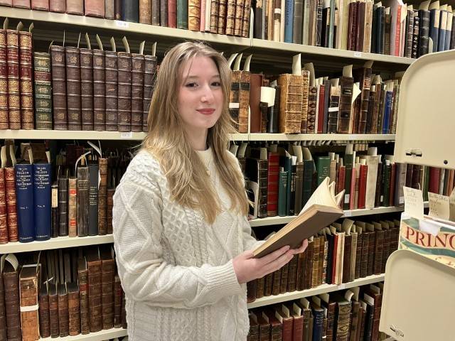 Alyssa Casey, inaugural Mattord Scholar, standing in the Bentley Rare Book Museum's stacks.