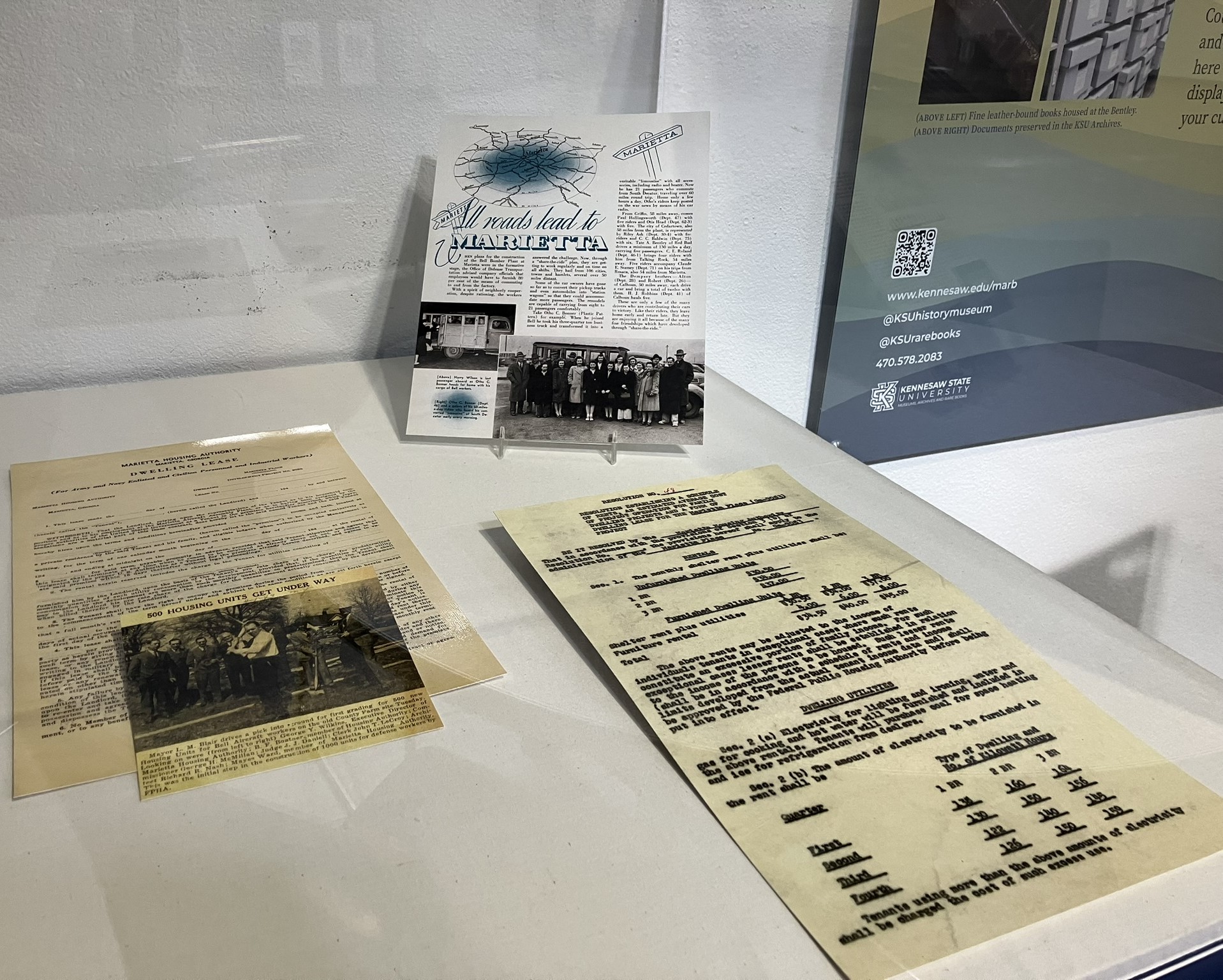 A close up of the spotlight cases showing various books, newspaper clippings and flyers from WWII