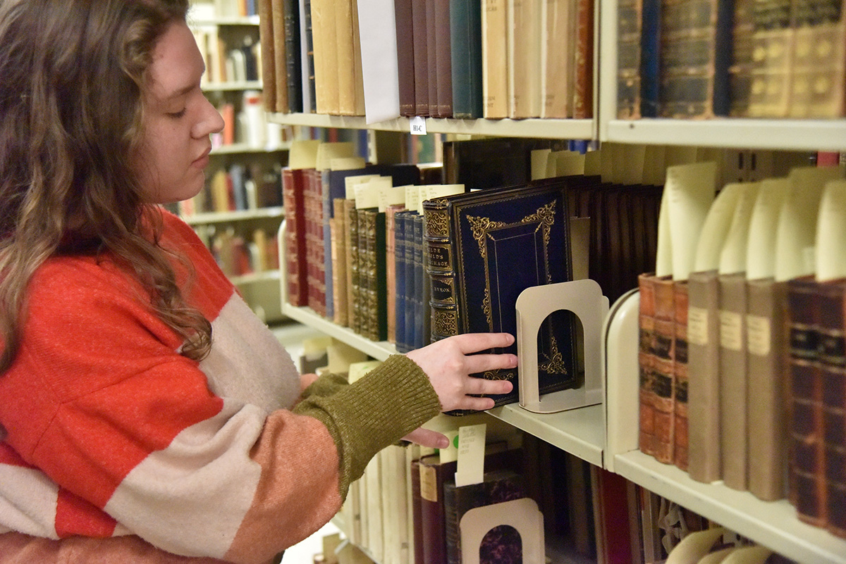 Student pulling a book from the Bentley Rare Book Stacks