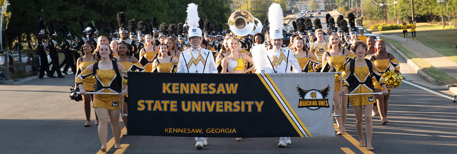 marching band in parade holding ksu banner