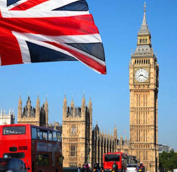 Big Ben, the iconic clock tower, with the Houses of Parliament and a British flag waving in the forground