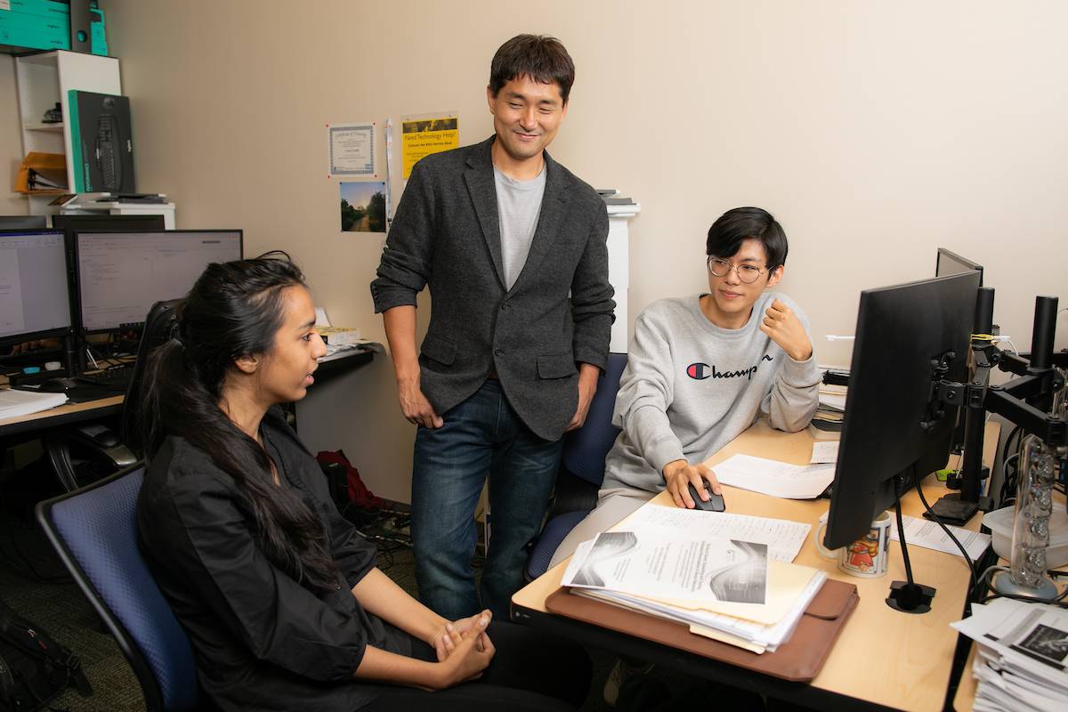 KSU CCSE associate professor Donghyun (David) Kim, center, talks with Jhilakshi Sharma, left, and Hong Kyu Lee in the Security, Privacy, and Advanced Computing Laboratory