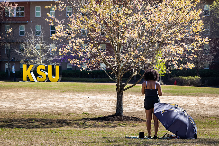 student standing in front of tree on marietta campus.