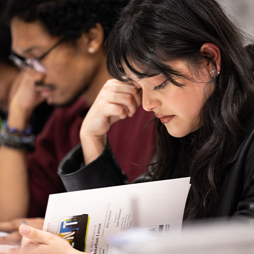 ksu graduate student looking down at a flyer.