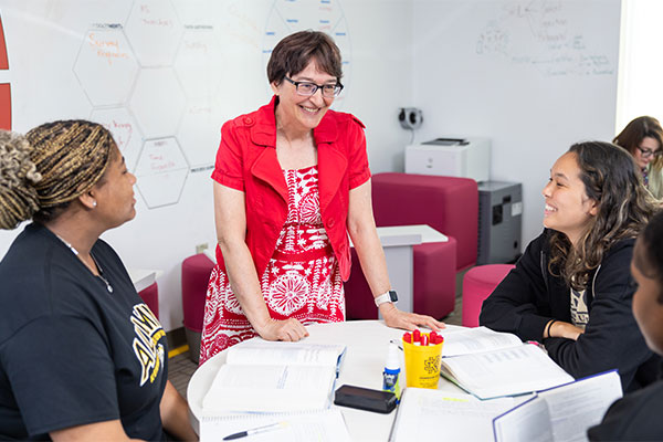 faculty working with a group of students.