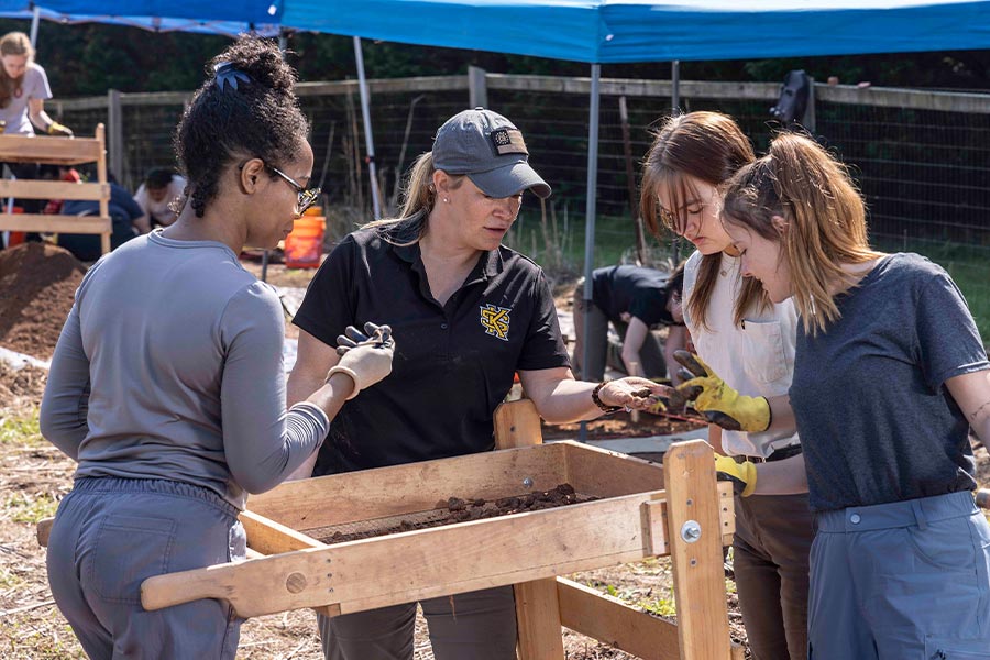 group of students outside researching the dirt at the field lab.