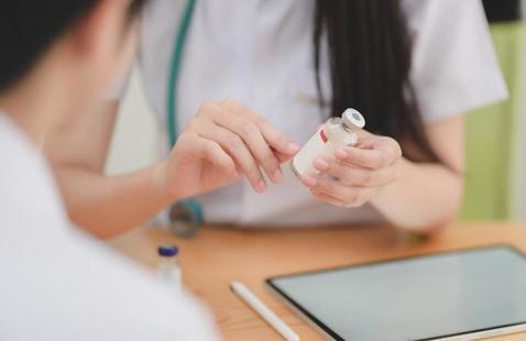 a nurse holding a medice vial