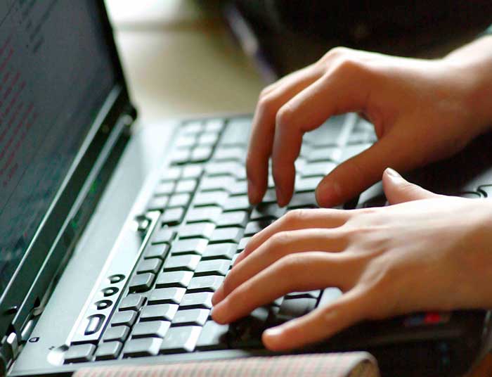 Student typing on laptop