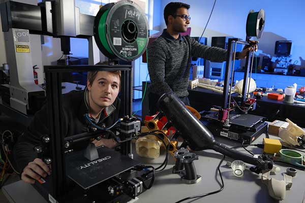 Two students working in a lab on expensive university equipment