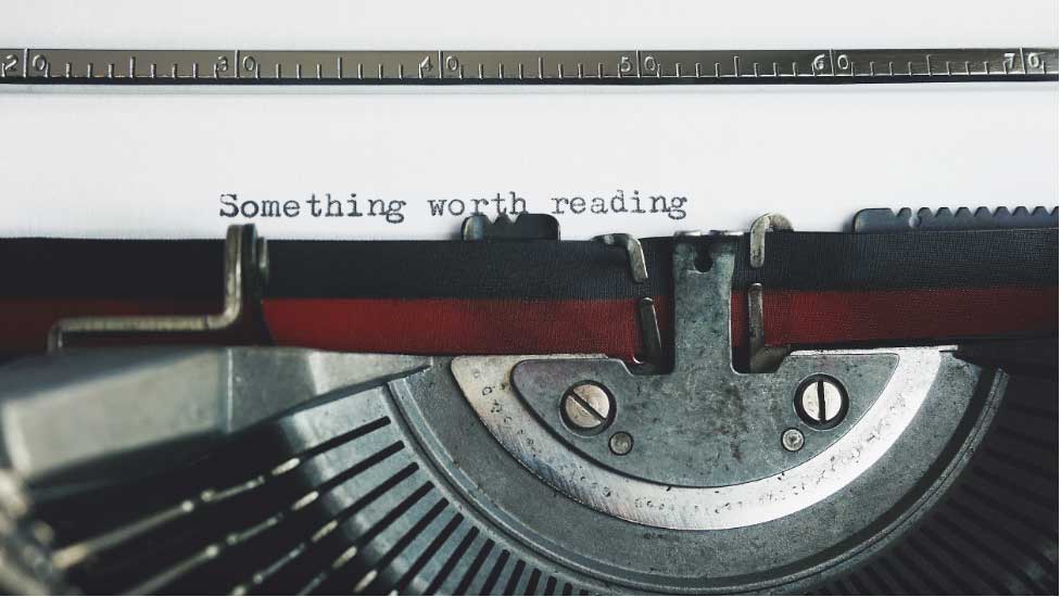 Typewritter typing the words "Something Worth Reading"