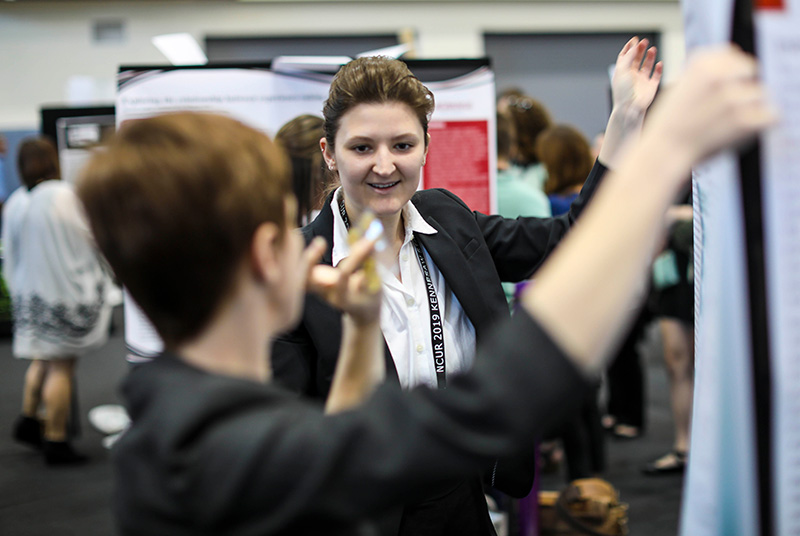 A KSU ProfessorMentoring Undergraduate Reseacher on their poster project during a conference