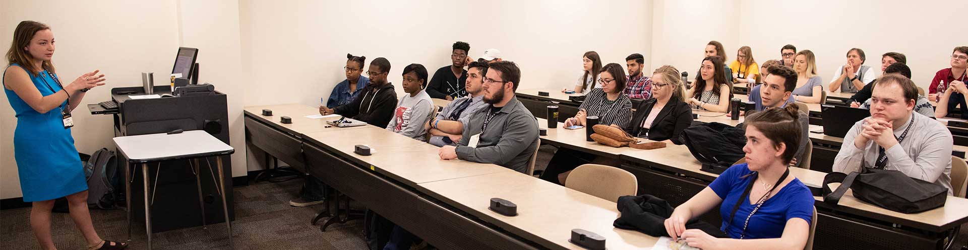 Instructor teach a class full of students on How to Make an Oral Presentation