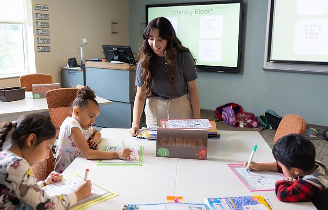 teacher helping a young child with their class work.