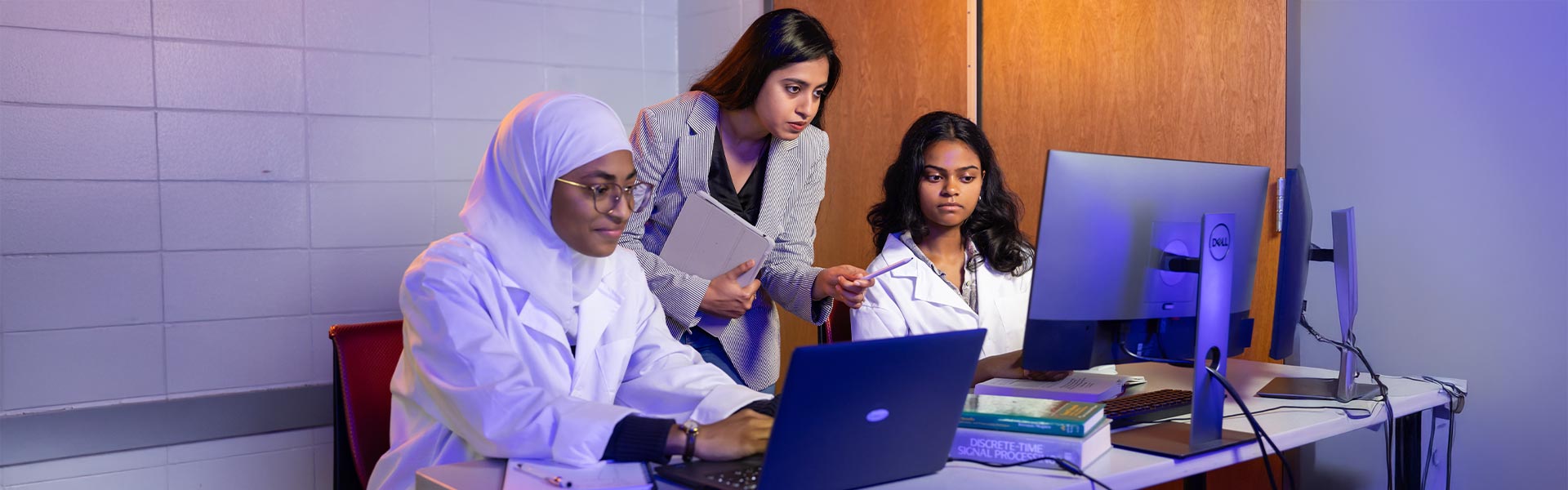 group of ksu faculty and students using their computer to research.