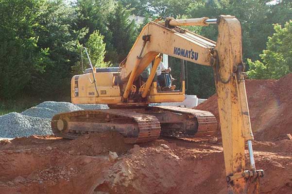 tractor digging holes in the environment