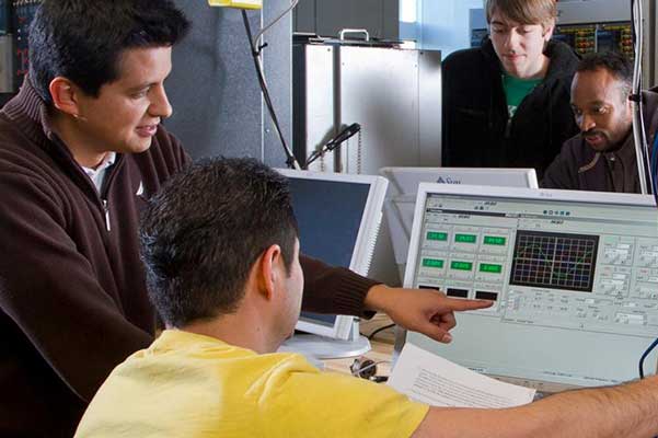 professor helping student at computer screen